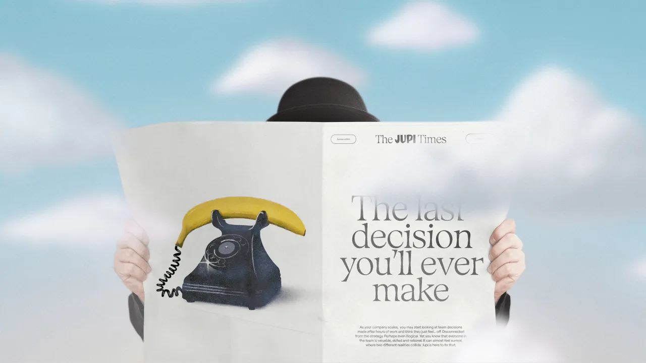 Person holding Jupi Times newspaper featuring a surreal illustration of a rotary telephone with a melting banana handset against a blue sky with clouds