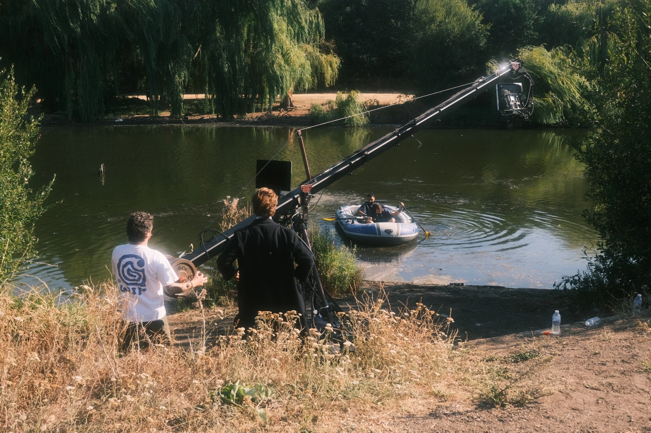 Film crew operating a crane with mounted camera over a river to shoot scenes for a low-budget remake of The Odyssey